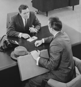 1950's businessman discussing financial services with a banker
