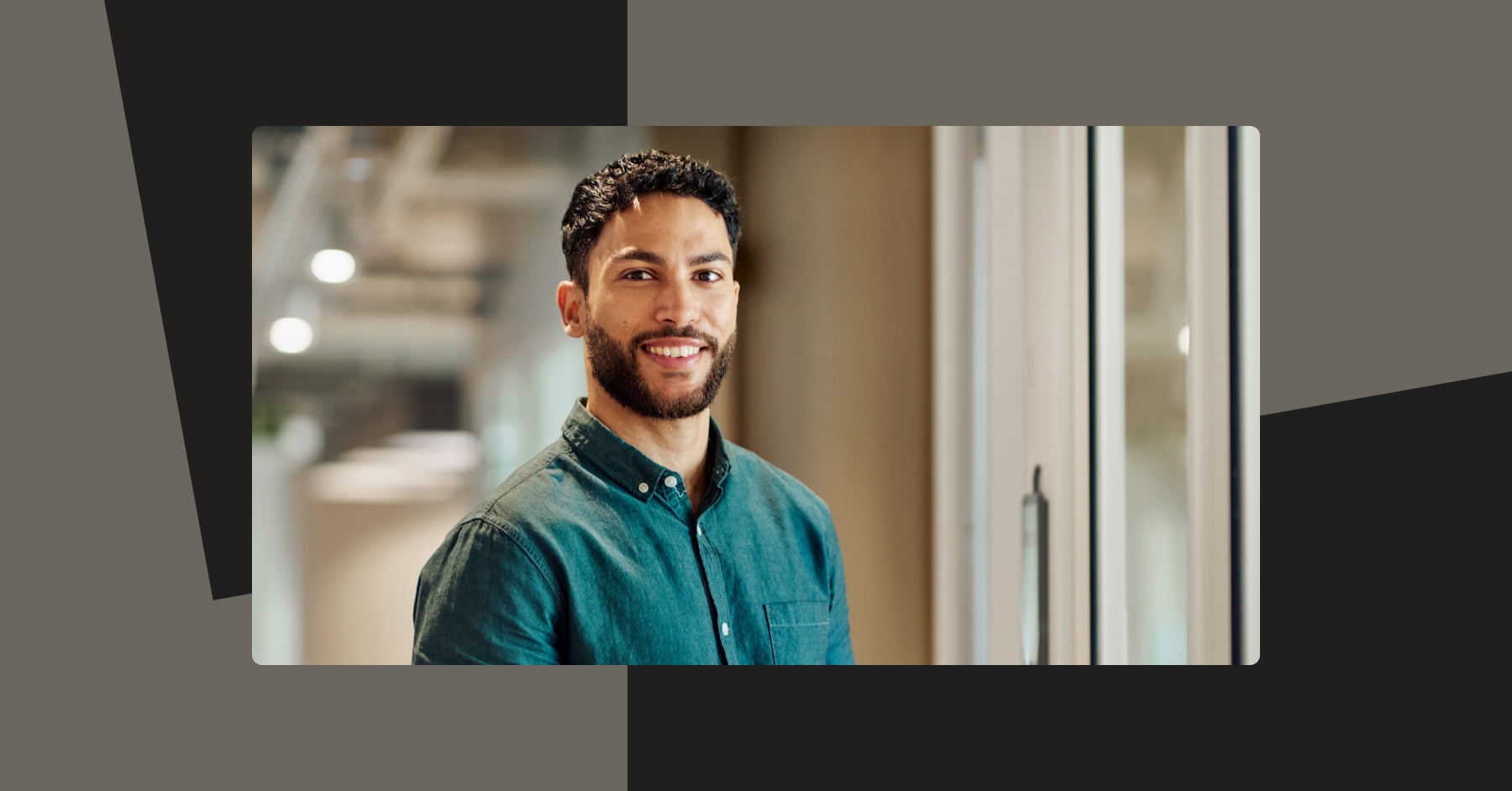Man in teal shirt looking at camera in office