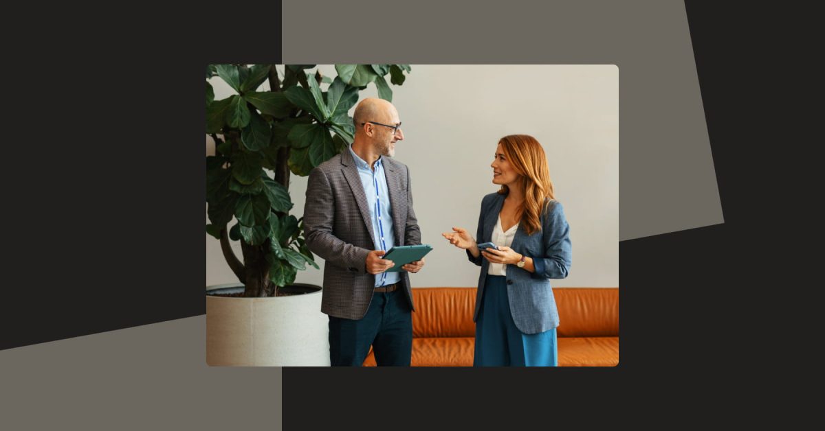 Two people standing in an office talking