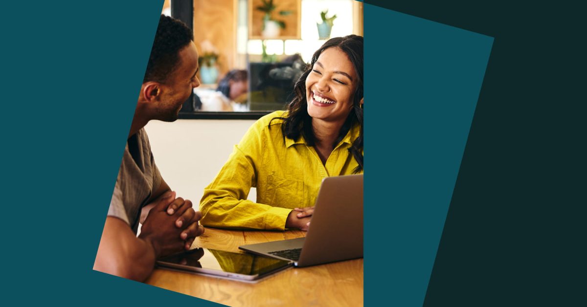 photo of two colleagues smiling and working together in an office