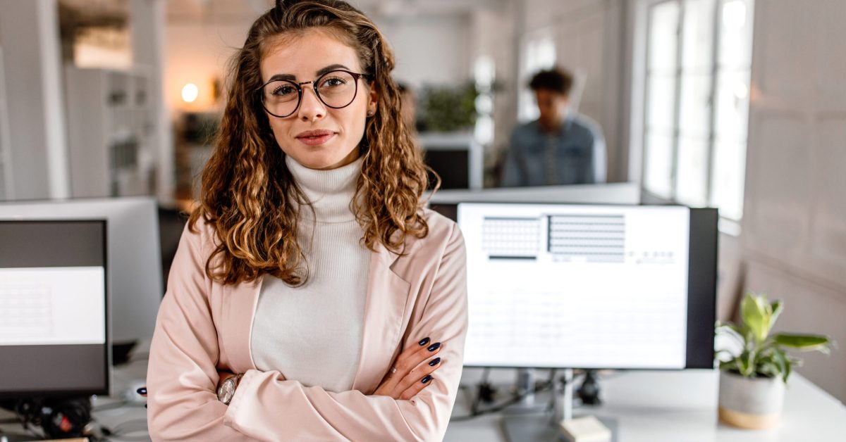 Young woman wearing glasses arms crossed looking confident