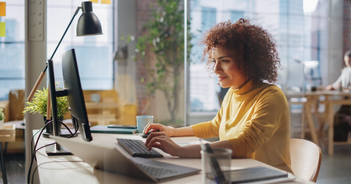 Woman at computer looking satisfied with results displayed