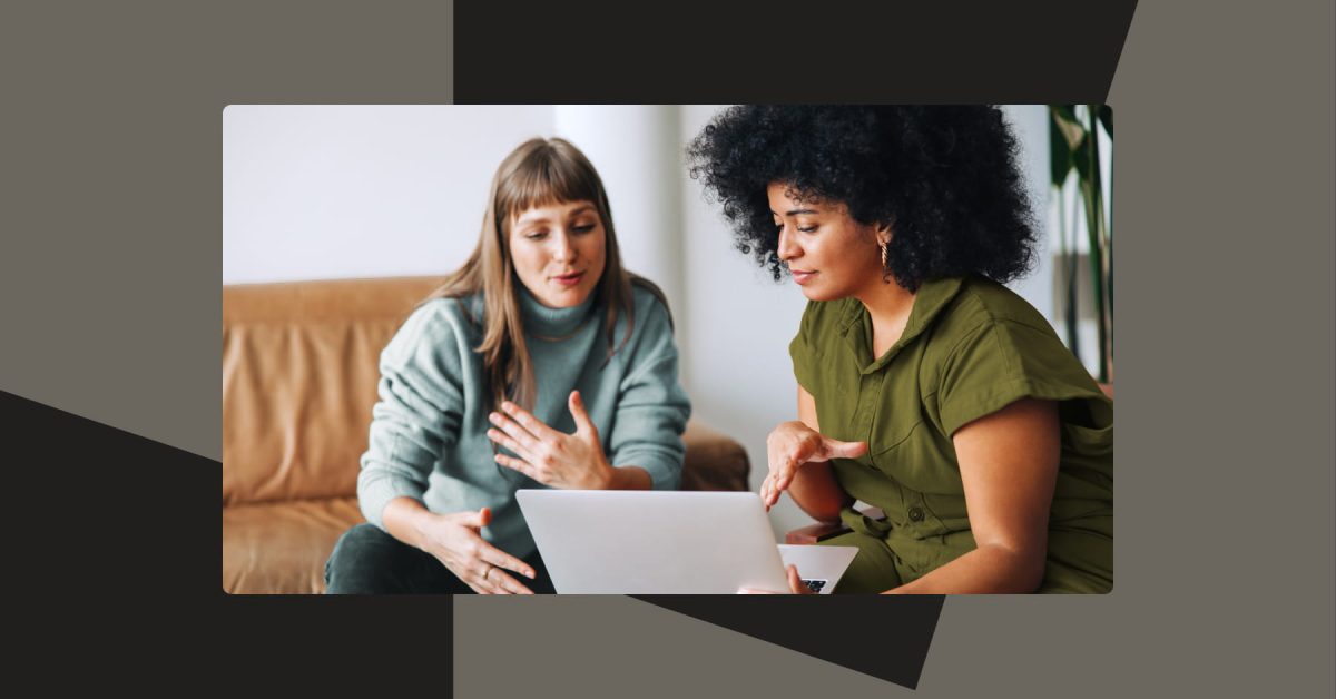 Two women in candid conversation seated in an office