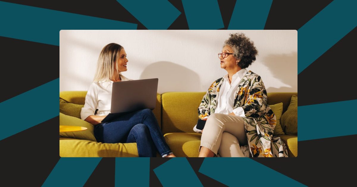 Two women talking on a couch in an office