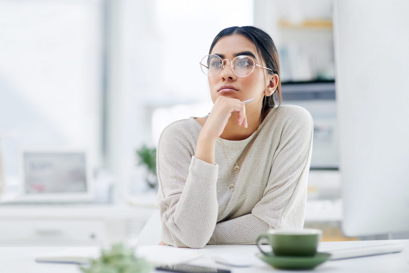 Shot of a young businesswoman looking thoughtful while working in an office.